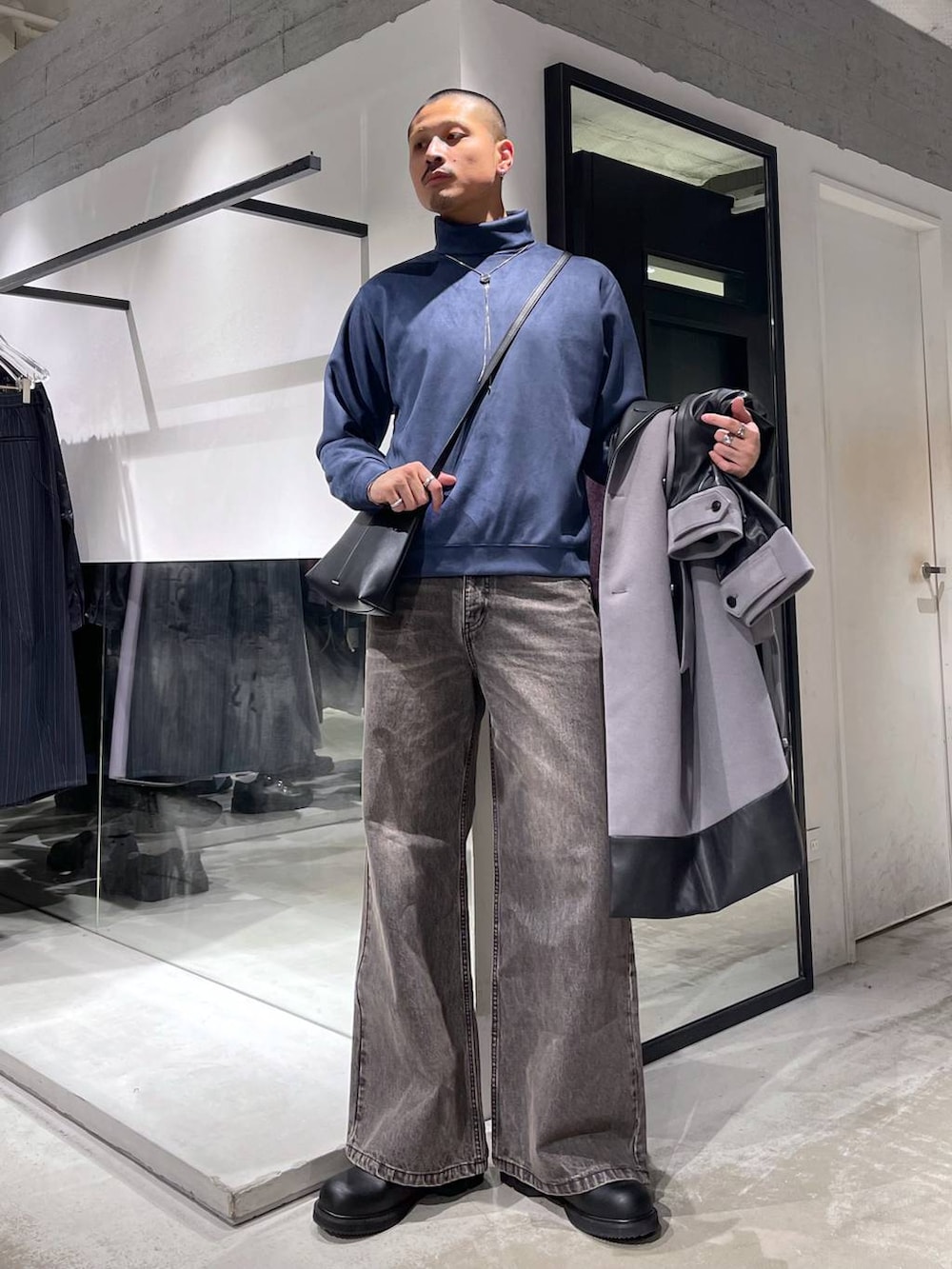 グレー系のトレンチコート、ブラウン系のデニムパンツ、ブラック系のドレスシューズを着用したメンズの冬コーディネートの5枚目の写真