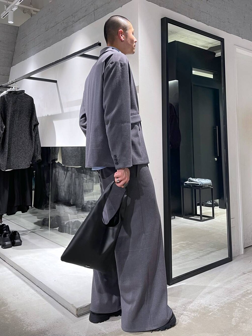 ブラック系のトートバッグ、ブラック系のドレスシューズ、グレー系のテーラードジャケットを着用したメンズの冬コーディネートの4枚目の写真