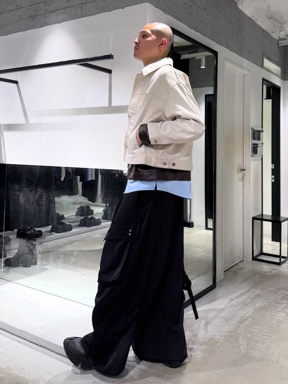 ホワイト系のデニムジャケット、ブラック系のバックパック/リュック、ブラック系のカーゴパンツを着用したメンズの春コーディネートの2枚目の写真