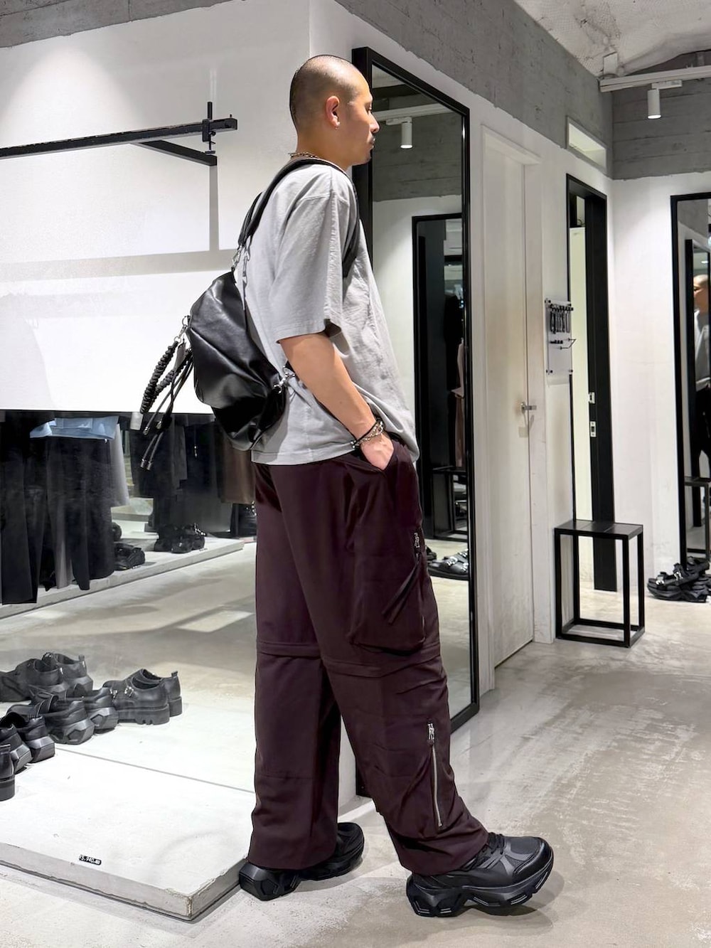 グレー系のTシャツ/カットソー、ブラック系のスニーカー、ブラウン系のカーゴパンツを着用したメンズの夏コーディネートの4枚目の写真