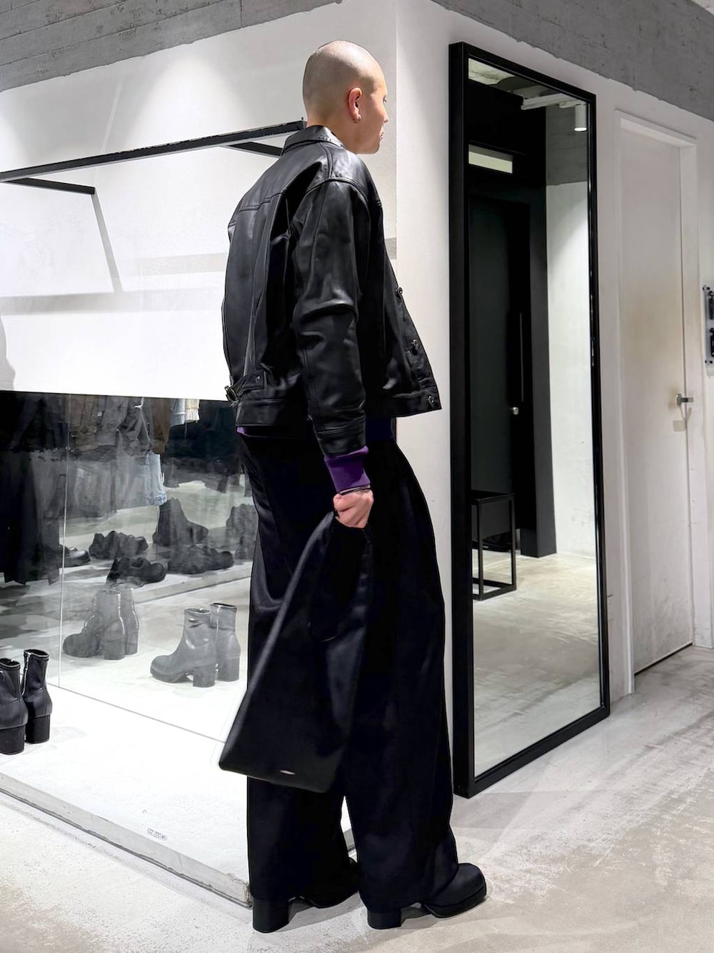 ブラック系のトートバッグ、ブラック系のブーツ、パープル系のスウェットを着用したメンズの冬コーディネートの2枚目の写真