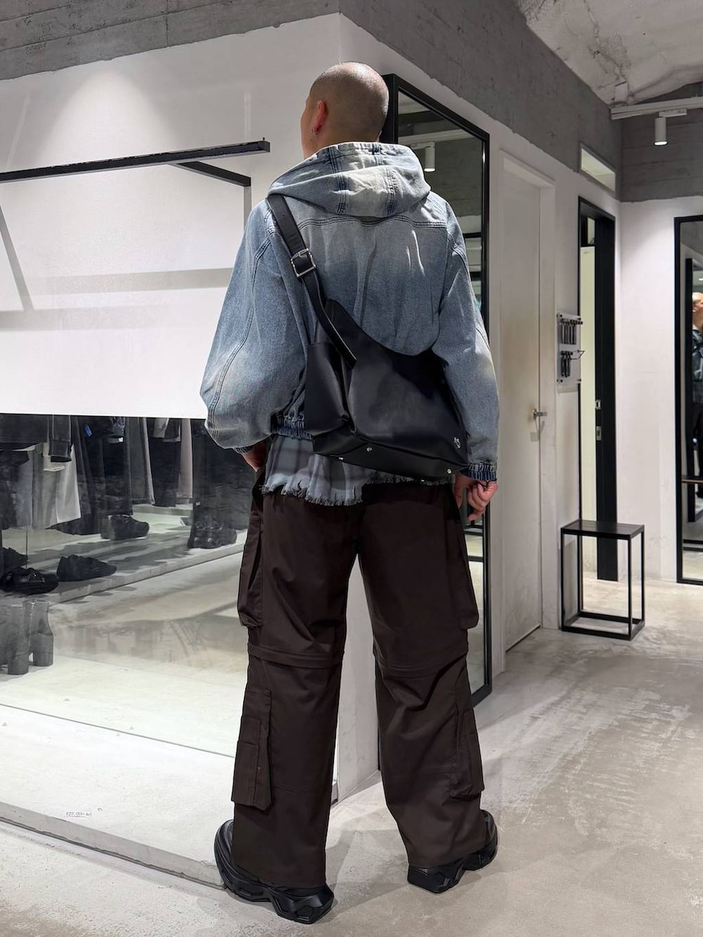 ブラック系のスニーカー、ブルー系のブルゾン、ブラウン系のカーゴパンツを着用したメンズの春コーディネートの3枚目の写真