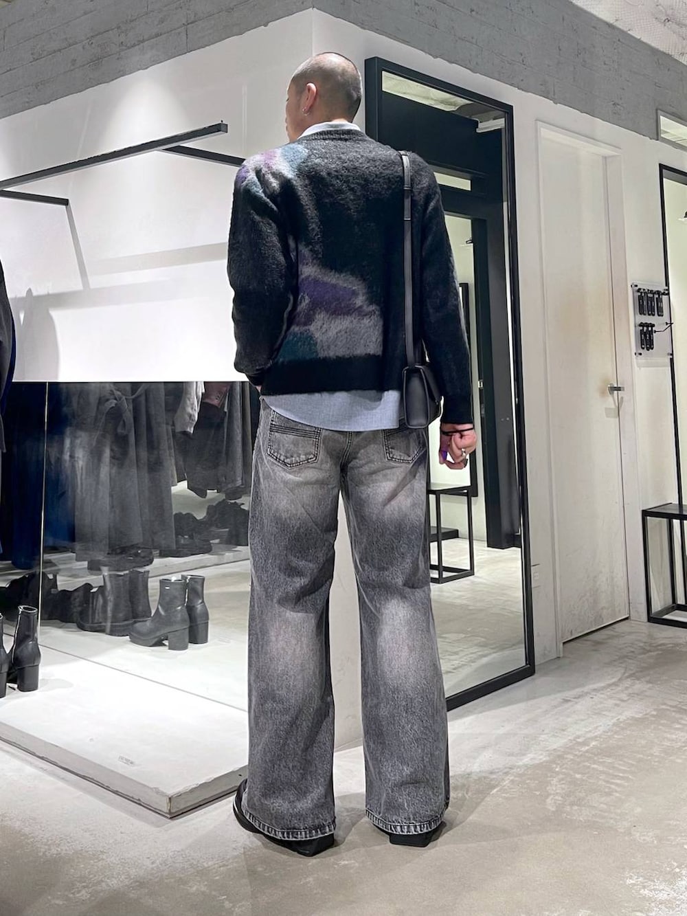 グレー系のデニムパンツ、ブラック系のローファー、ブラック系のショルダーバッグを着用したメンズの冬コーディネートの3枚目の写真