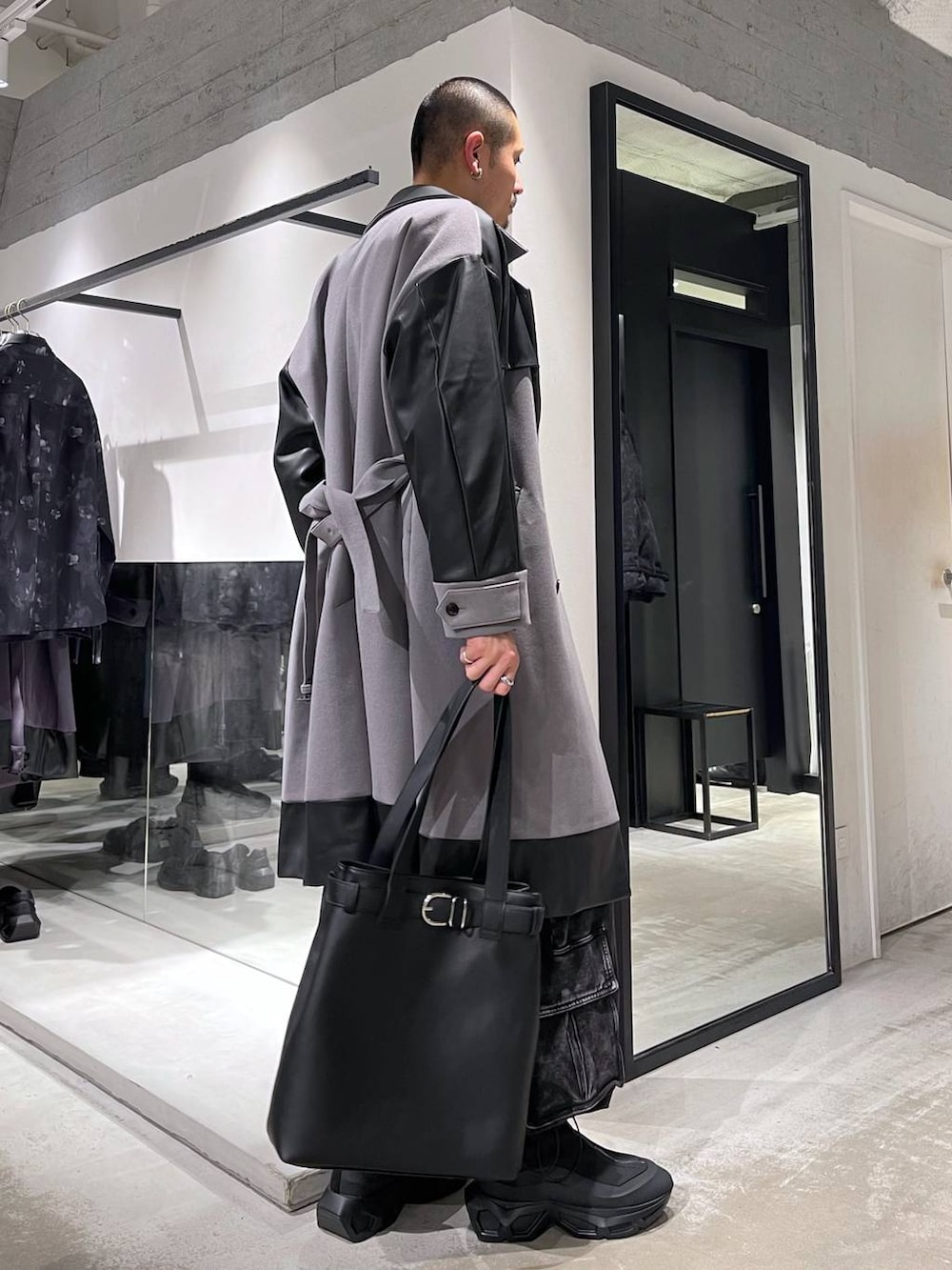 グレー系のトレンチコート、ブルー系のカーディガン/ボレロ、ブラック系のトートバッグを着用したメンズの冬コーディネートの4枚目の写真