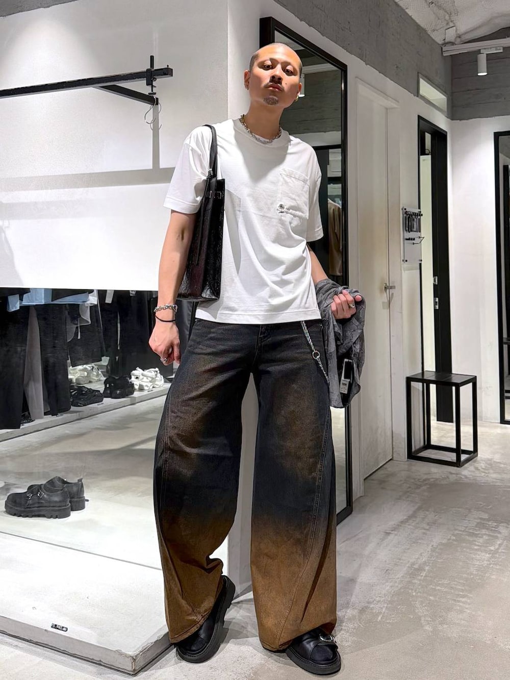 オレンジ系のデニムパンツ、ホワイト系のTシャツ/カットソー、ブラック系のサンダルを着用したメンズの夏コーディネートの5枚目の写真