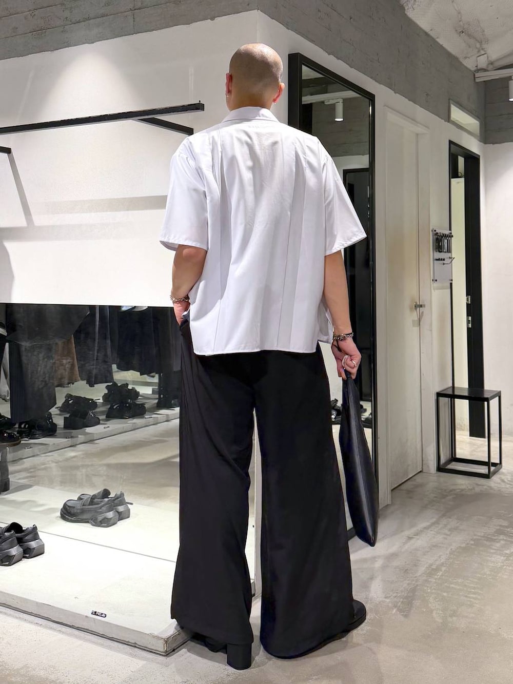 ブラック系のトートバッグ、ブラック系のサンダル、ブルー系のTシャツ/カットソーを着用したメンズの夏コーディネートの3枚目の写真