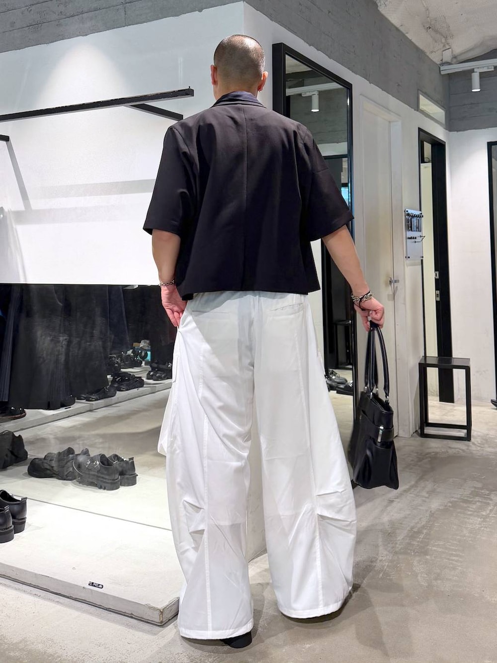 ブラック系のサンダル、ブラック系のトートバッグ、グレー系のブレスレットを着用したメンズの夏コーディネートの3枚目の写真