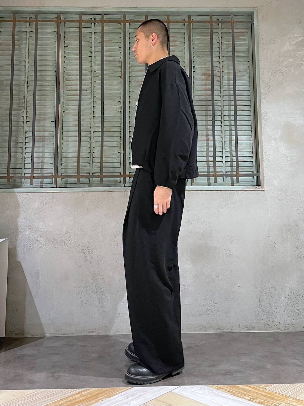 ブラック系のブーツ、ホワイト系のニット/セーター、シルバー系のネックレスを着用したメンズの秋コーディネートの2枚目の写真