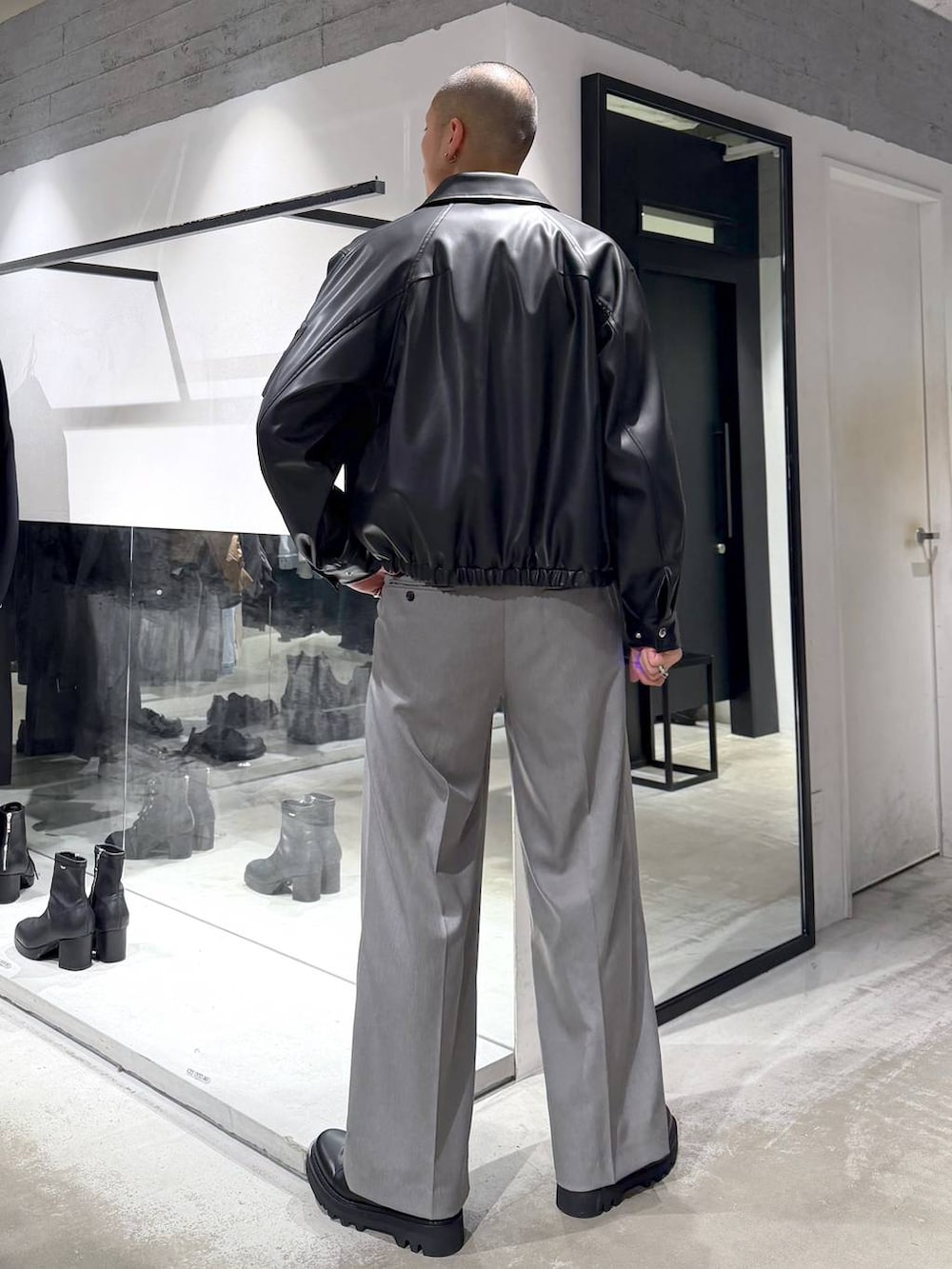 ブラック系のブルゾン、ブラック系のドレスシューズ、ブラック系のハンドバッグを着用したメンズの冬コーディネートの3枚目の写真