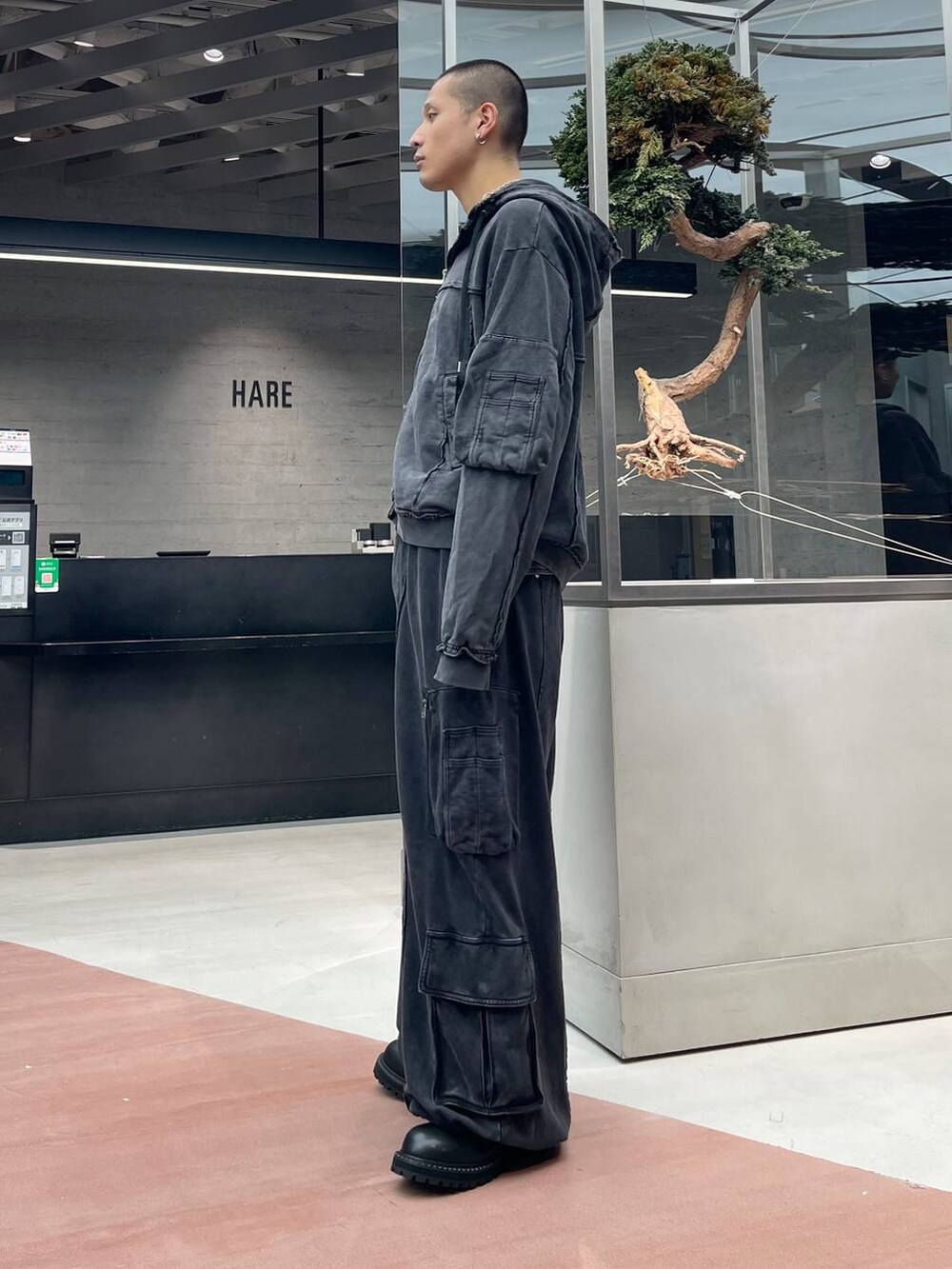 ブラック系のスウェットパンツ、ブラック系のパーカー、ブラック系のブーツを着用したメンズの秋コーディネートの2枚目の写真