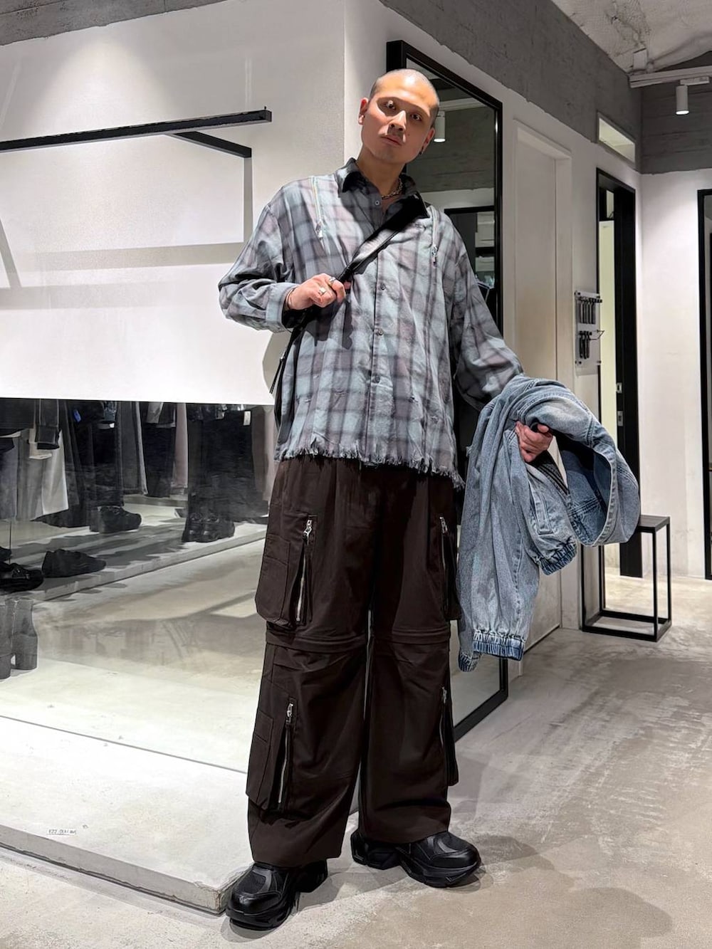 ブラック系のスニーカー、ブルー系のブルゾン、ブラウン系のカーゴパンツを着用したメンズの春コーディネートの5枚目の写真