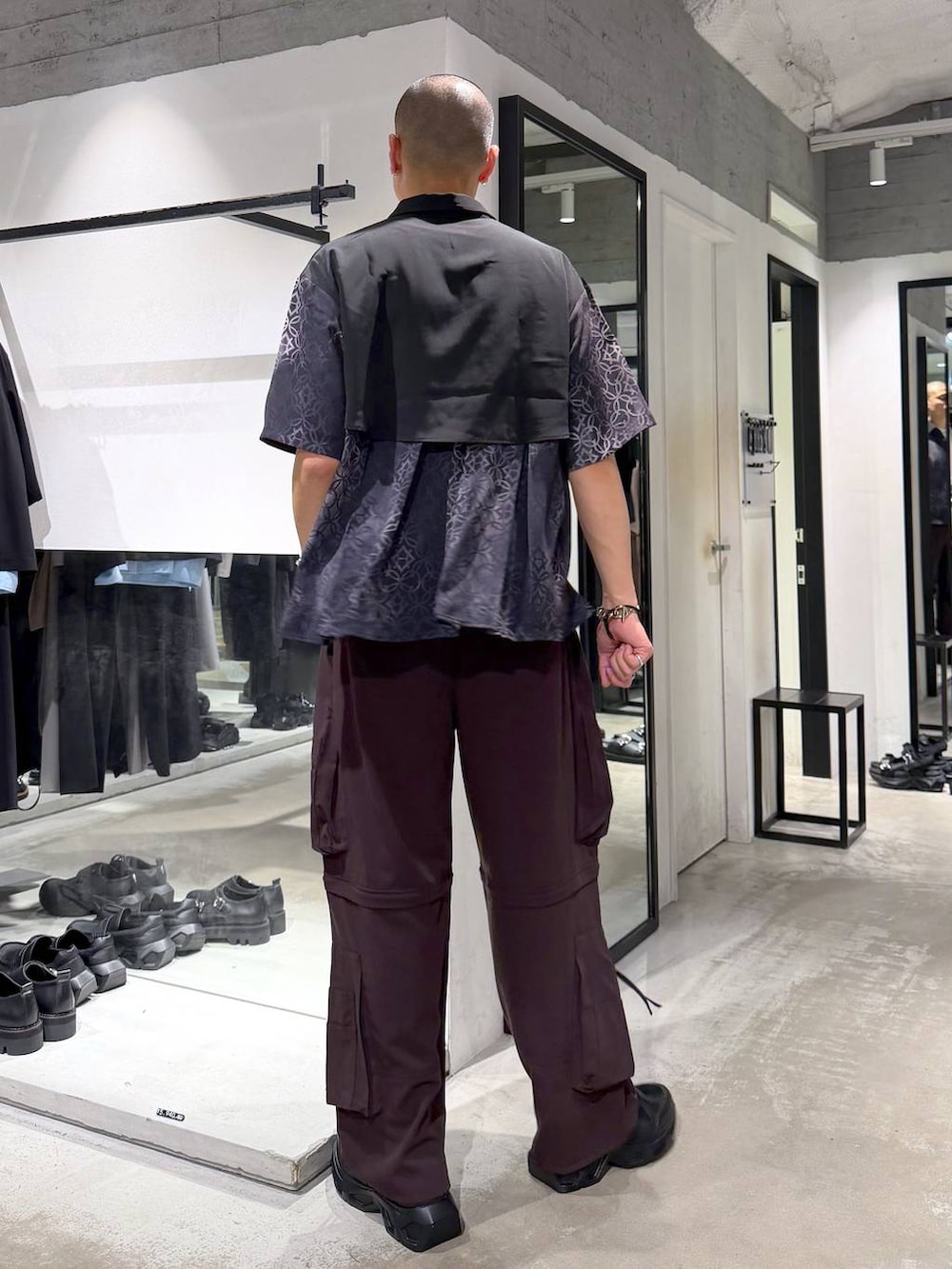 ブラック系のスニーカー、ブラウン系のカーゴパンツ、ブラック系のシャツ/ブラウスを着用したメンズの夏コーディネートの3枚目の写真