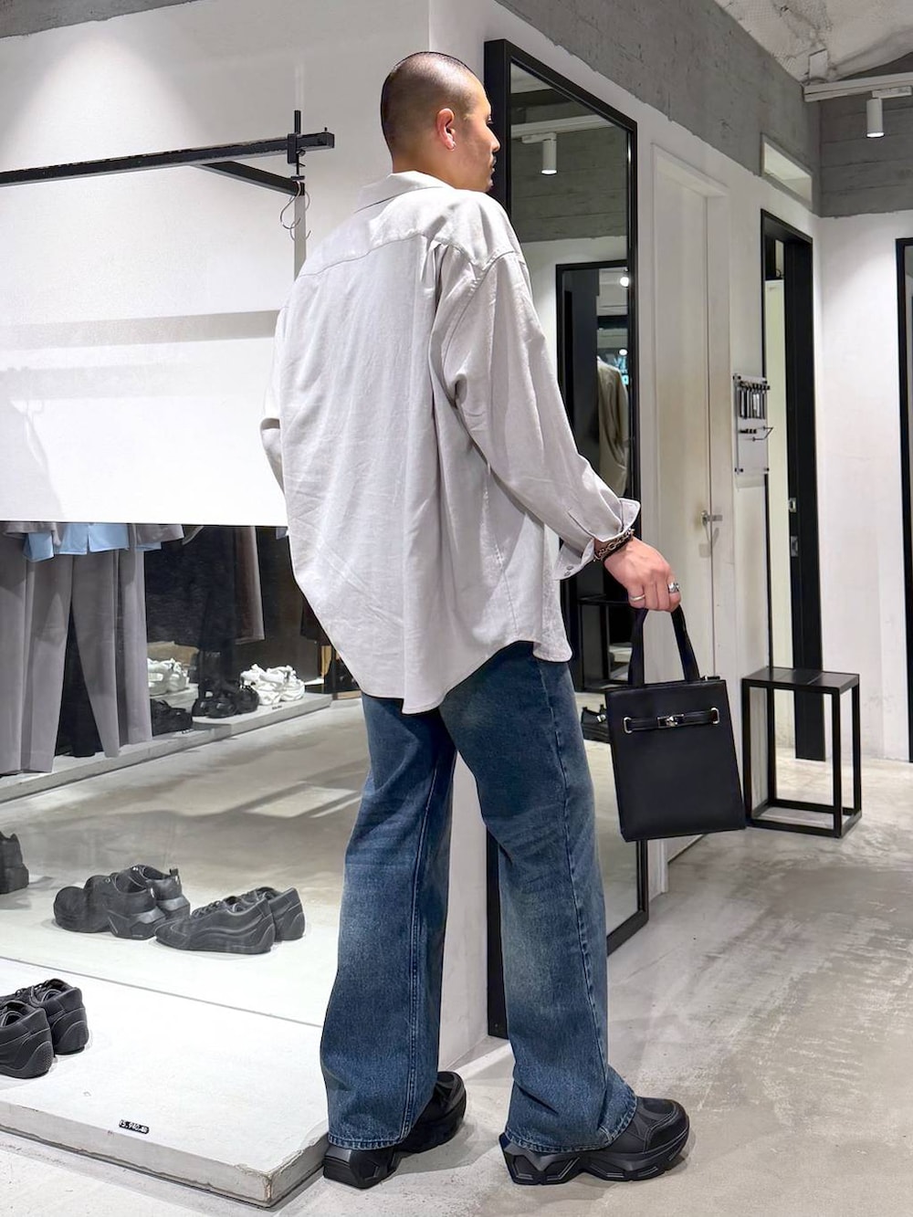 グレー系のシャツ/ブラウス、ブラック系のスニーカー、ブルー系のデニムパンツを着用したメンズの夏コーディネートの4枚目の写真
