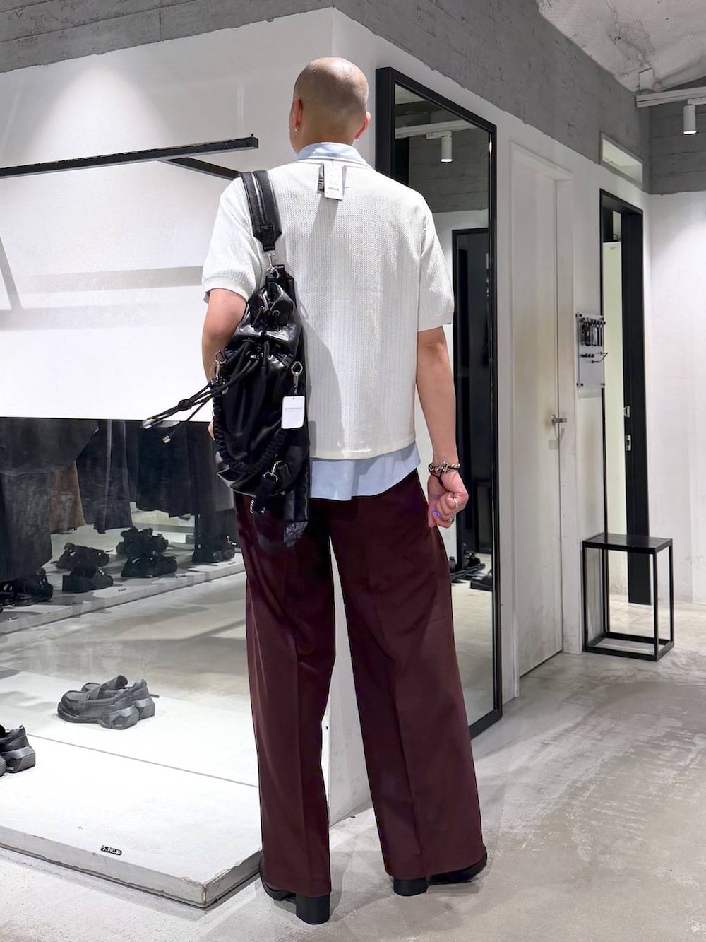 ブラック系のサンダル、レッド系のスラックス、ホワイト系のニット/セーターを着用したメンズの夏コーディネートの3枚目の写真