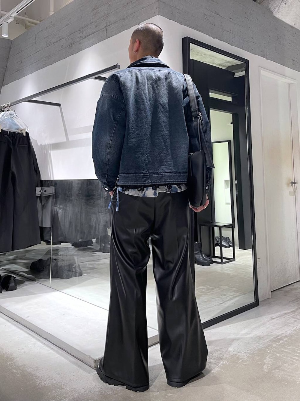 ブラック系のスラックス、ブラック系のドレスシューズ、ブラック系のショルダーバッグを着用したメンズの冬コーディネートの3枚目の写真