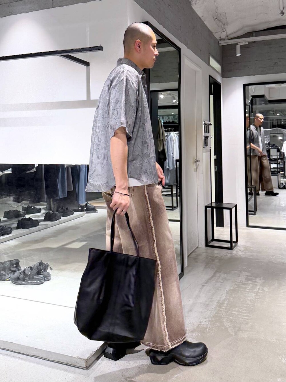 ホワイト系のTシャツ/カットソー、ブラック系のドレスシューズ、ブラック系のトートバッグを着用したメンズの春コーディネートの4枚目の写真