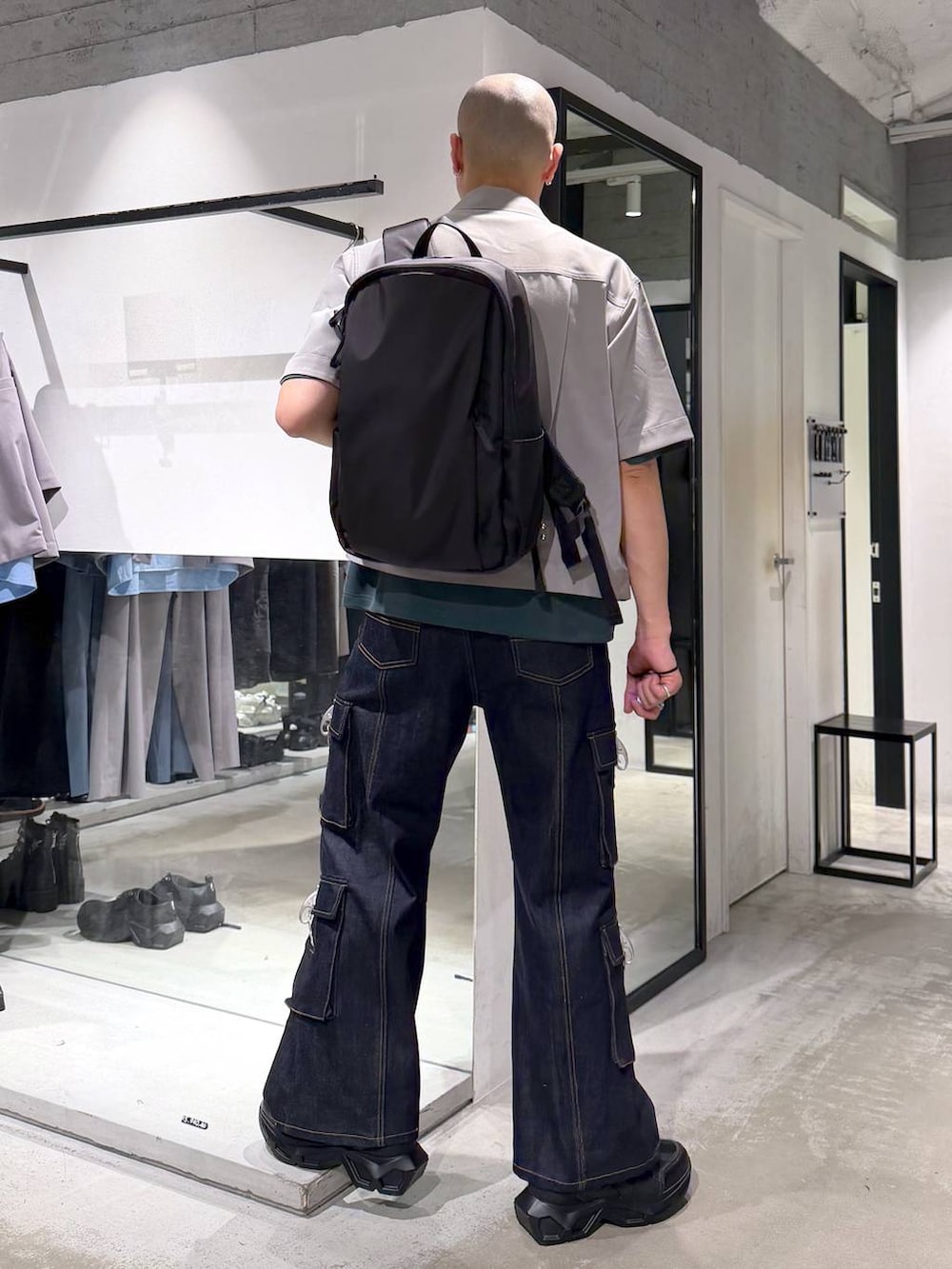 ブラック系のスニーカー、ブラック系のバックパック/リュック、ブルー系のデニムパンツを着用したメンズの夏コーディネートの3枚目の写真