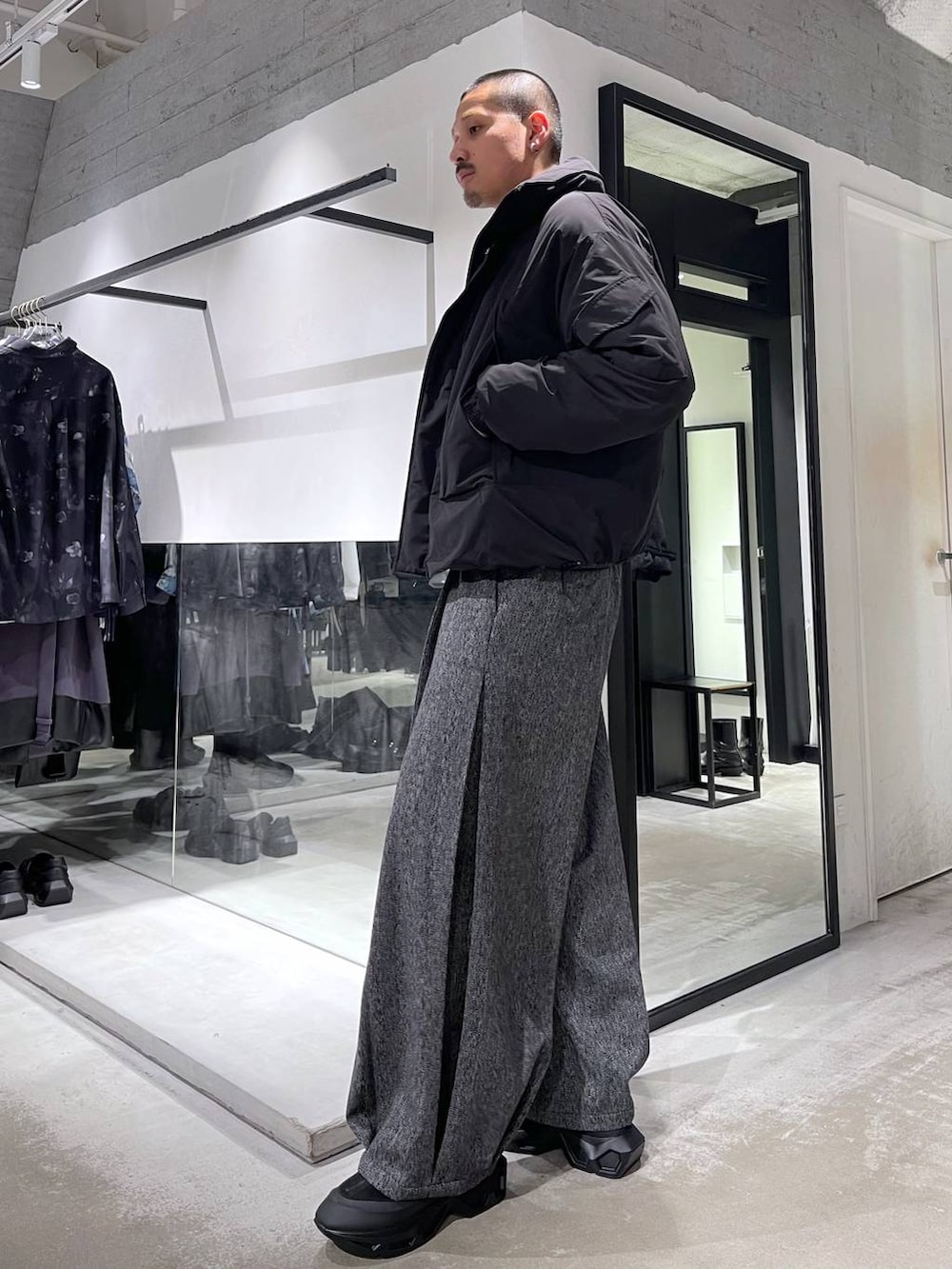 ブラック系のニット/セーター、ブラック系のダウンジャケット/コート、ブラック系のスラックスを着用したメンズの冬コーディネートの2枚目の写真