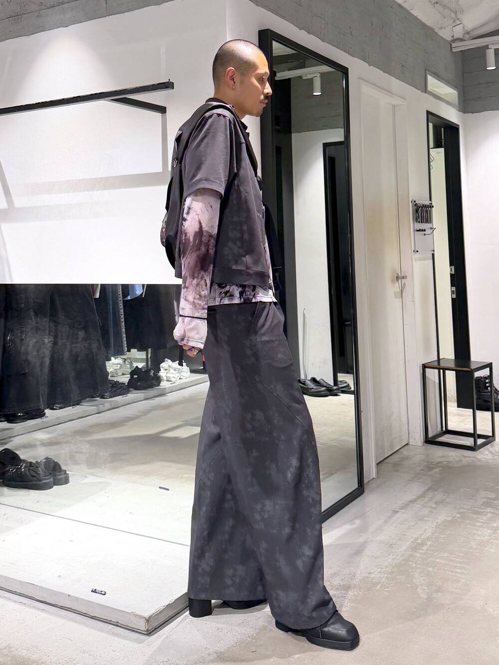 ブラック系のサンダル、ブラック系のショルダーバッグ、グレー系のスラックスを着用したメンズの夏コーディネートの4枚目の写真