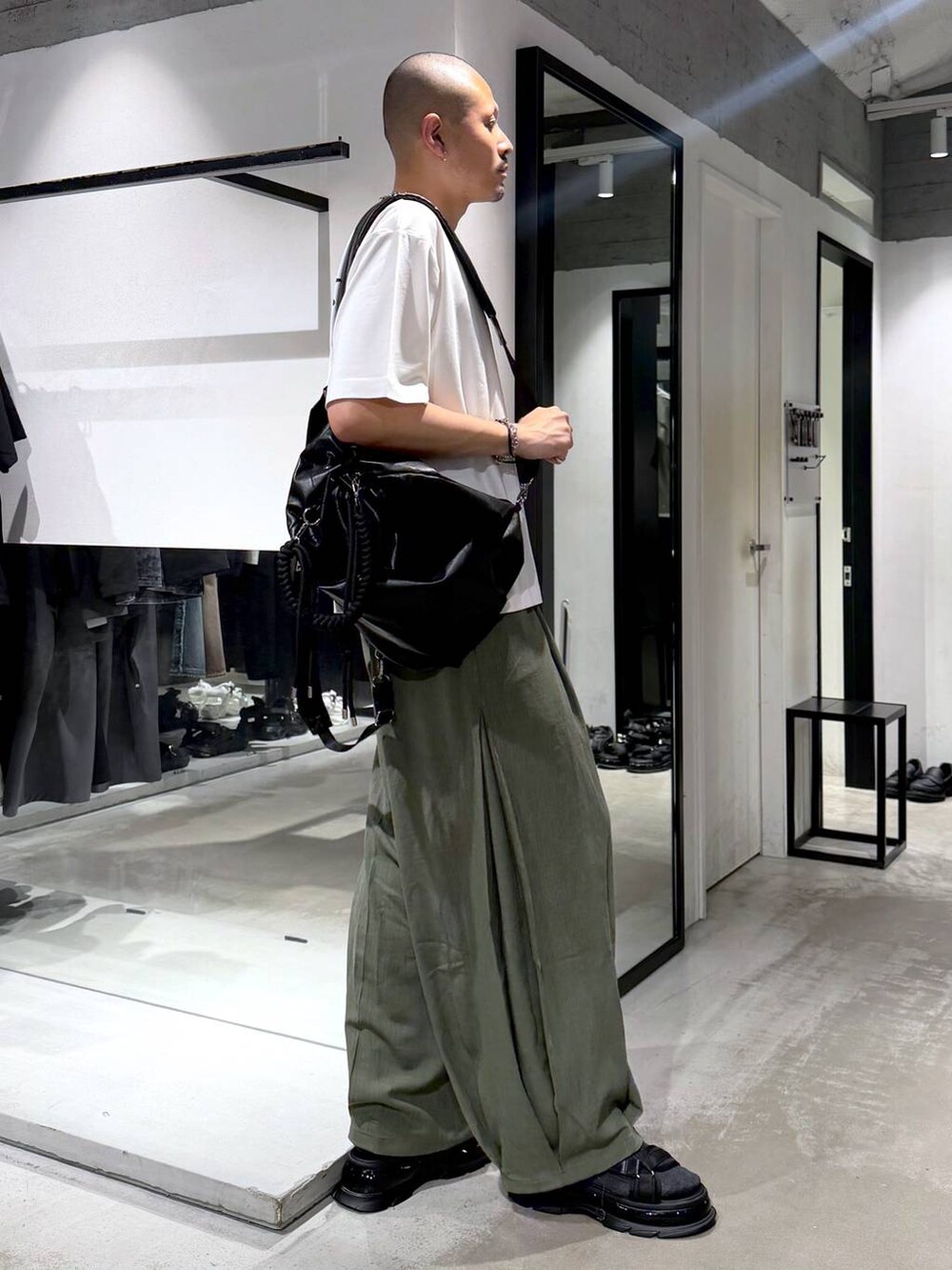 ブラック系のサンダル、グリーン系のスラックス、ホワイト系のTシャツ/カットソーを着用したメンズの夏コーディネートの4枚目の写真