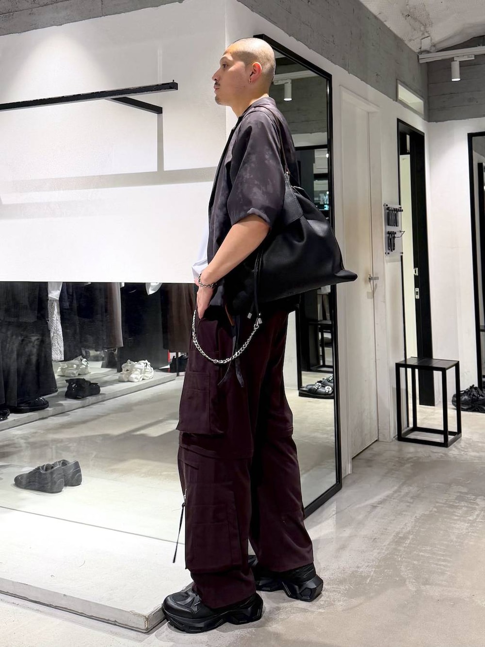 ブラック系のスニーカー、ブラウン系のカーゴパンツ、グレー系のテーラードジャケットを着用したメンズの夏コーディネートの2枚目の写真