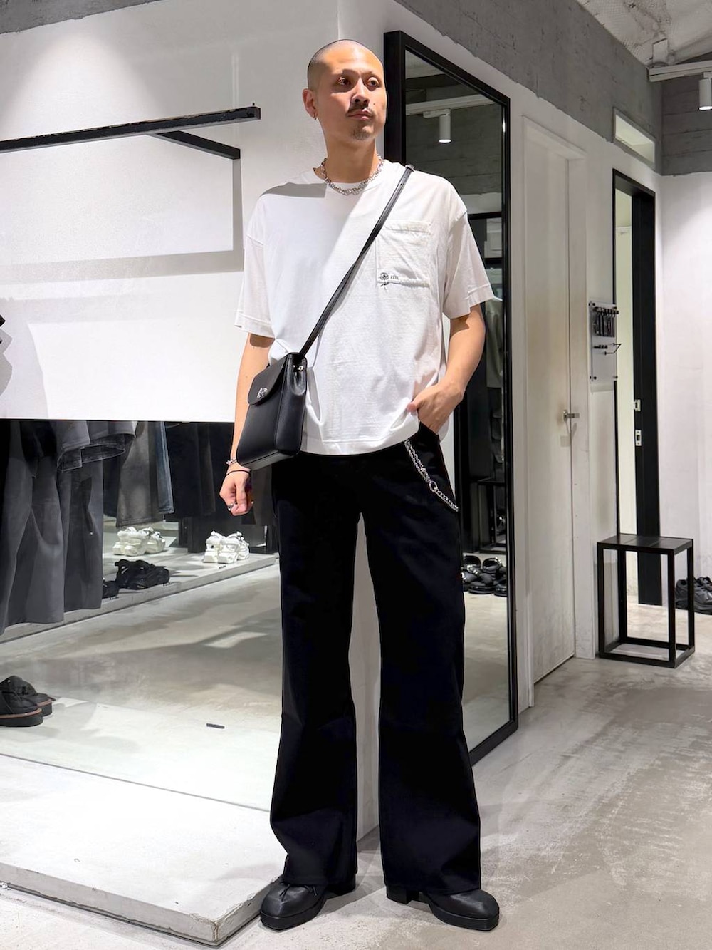 ブラック系のショルダーバッグ、ホワイト系のTシャツ/カットソー、ブラック系のサンダルを着用したメンズの夏コーディネートの5枚目の写真