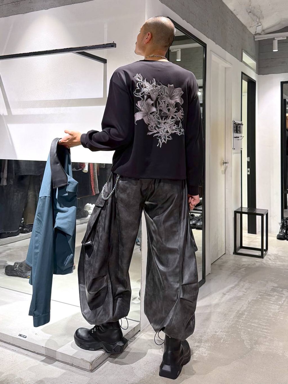 グリーン系のシャツ/ブラウス、ブラック系のブーツ、ブラック系のTシャツ/カットソーを着用したメンズの秋コーディネートの7枚目の写真