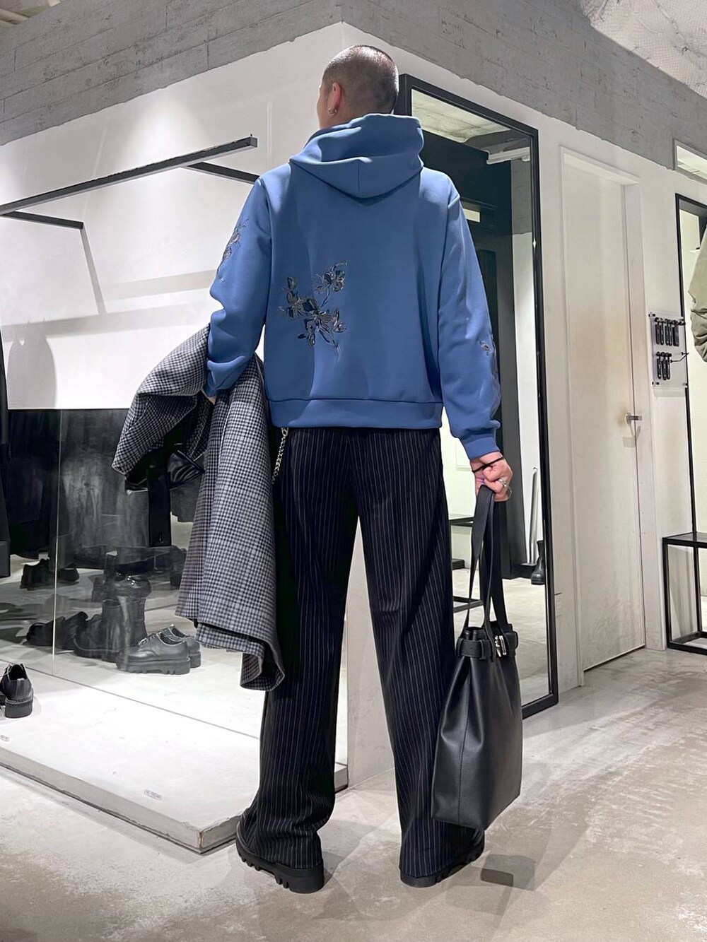 ベージュ系のステンカラーコート、ブラック系のトートバッグ、ブラック系のドレスシューズを着用したメンズの秋コーディネートの6枚目の写真