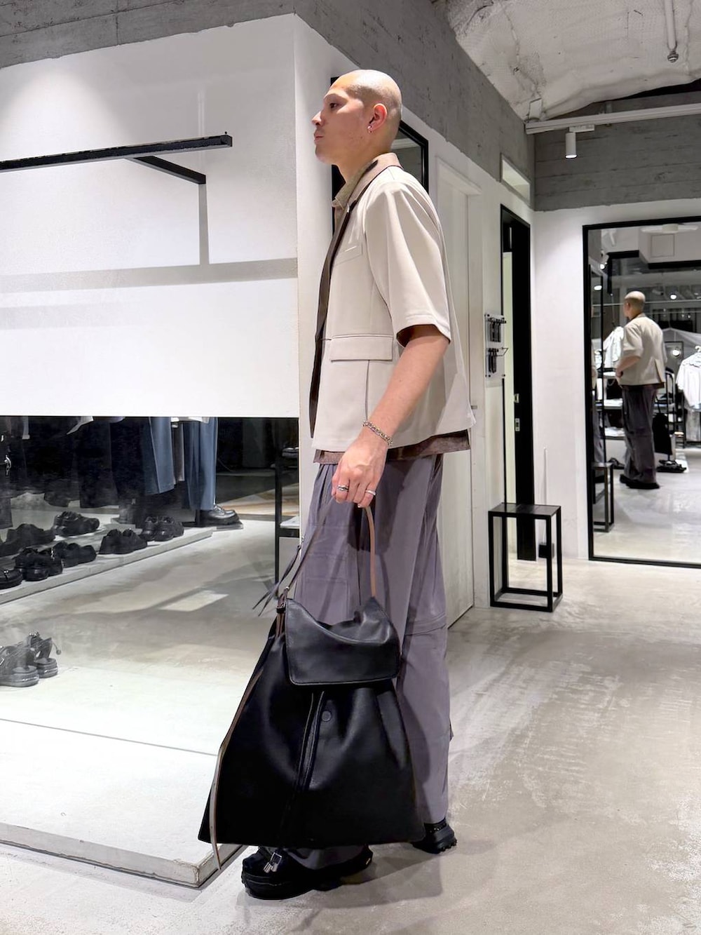 ブラック系のサンダル、グレー系のカーゴパンツ、ブラック系のトートバッグを着用したメンズの春コーディネートの2枚目の写真