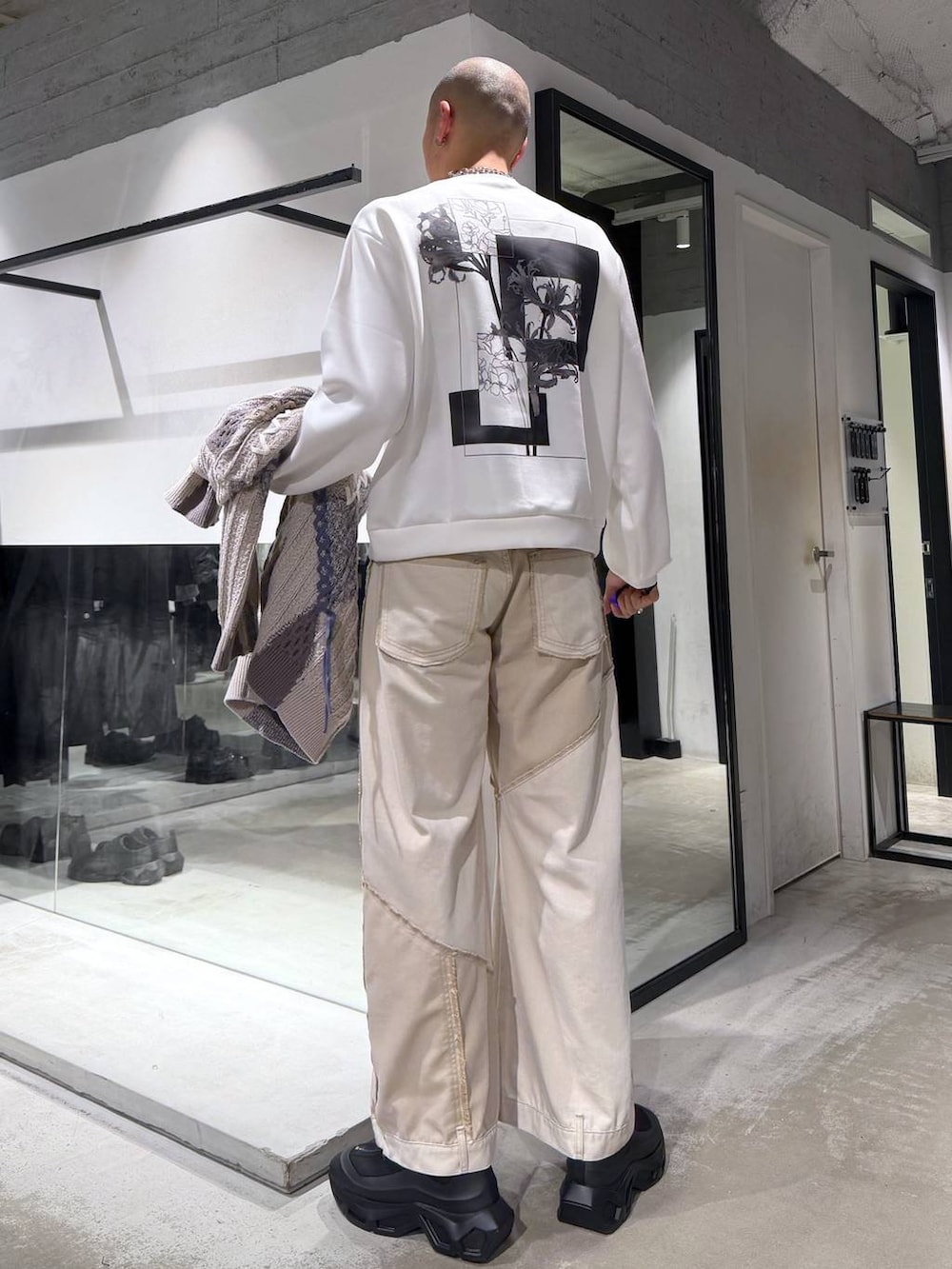 グレー系のカーディガン/ボレロ、ブラック系のブーツ、ホワイト系のブルゾンを着用したメンズの冬コーディネートの6枚目の写真