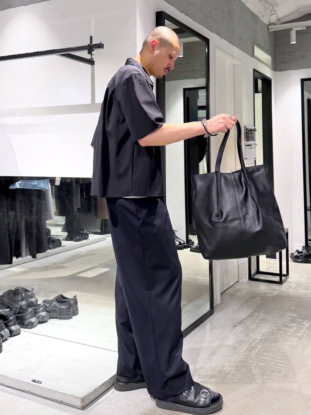 ホワイト系のTシャツ/カットソー、ブラック系のサンダル、ブラック系のトートバッグを着用したメンズの夏コーディネートの4枚目の写真