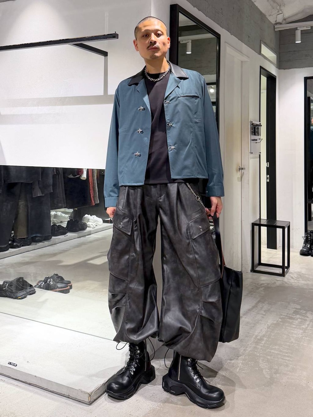グリーン系のシャツ/ブラウス、ブラック系のブーツ、ブラック系のTシャツ/カットソーを着用したメンズの秋コーディネートの5枚目の写真