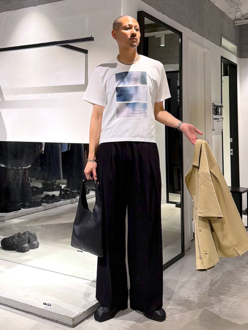 ホワイト系のTシャツ/カットソー、ブラック系のトートバッグ、ブラック系のサンダルを着用したメンズの夏コーディネートの5枚目の写真