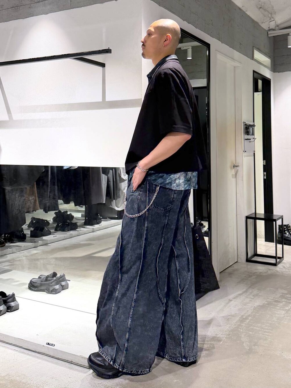 ブラック系のスニーカー、ブルー系のデニムパンツ、ブルー系のシャツ/ブラウスを着用したメンズの夏コーディネートの2枚目の写真