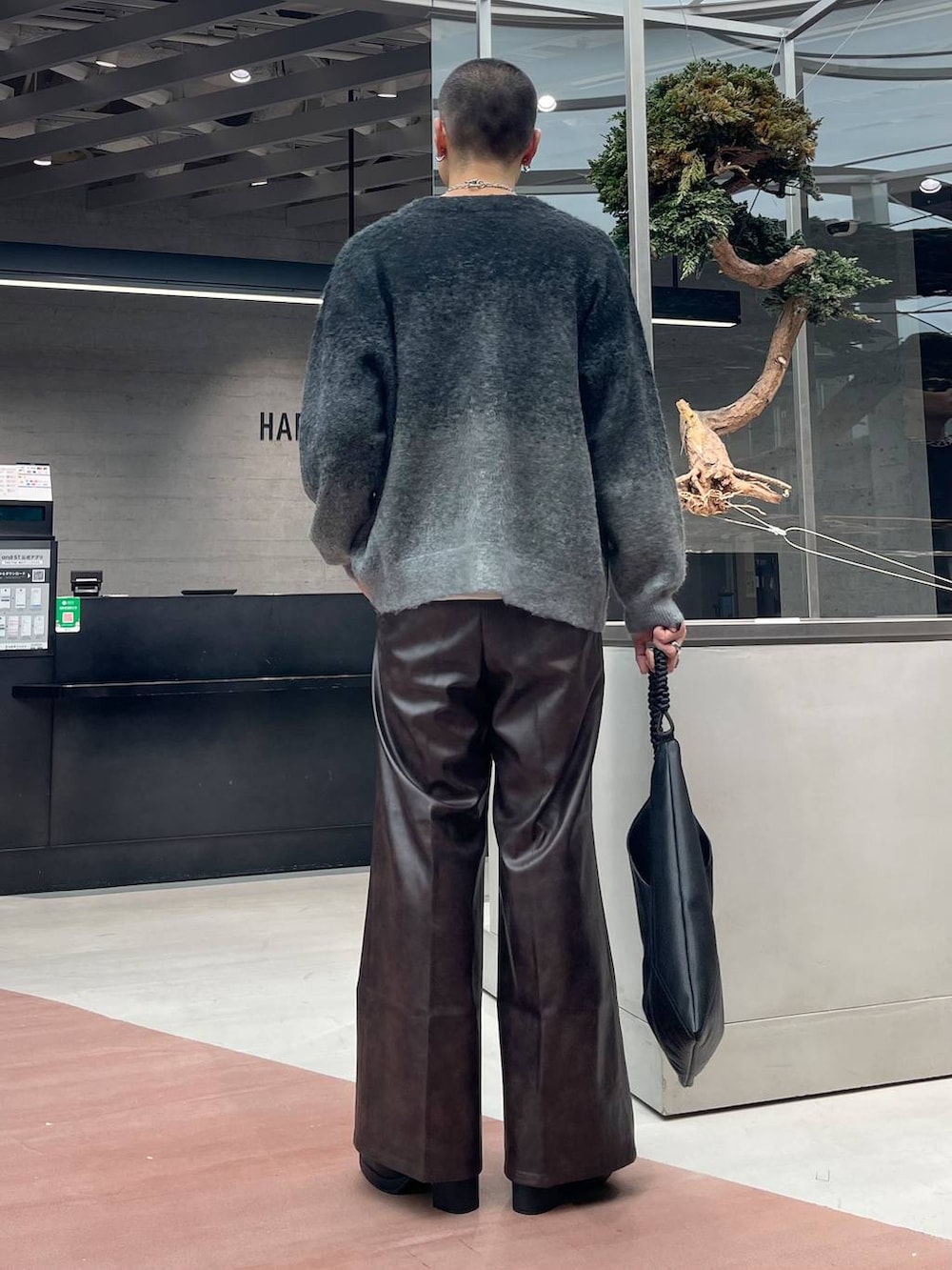 ブラック系のカーディガン/ボレロ、ブラウン系のスラックス、ブラック系のトートバッグを着用したメンズの秋コーディネートの3枚目の写真