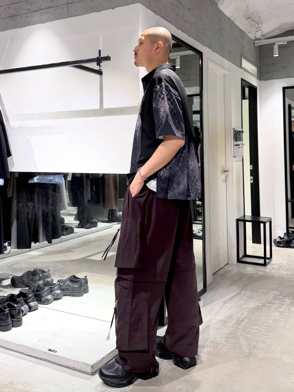 ブラック系のスニーカー、ブラウン系のカーゴパンツ、ブラック系のシャツ/ブラウスを着用したメンズの夏コーディネートの2枚目の写真