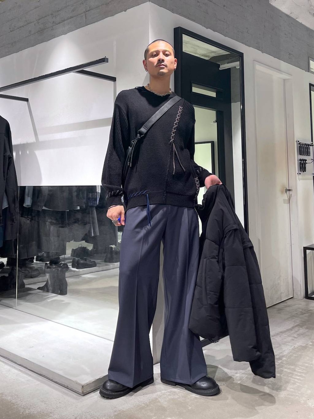 ブラック系のダウンジャケット/コート、ブラック系のブーツ、ブラック系のショルダーバッグを着用したメンズの冬コーディネートの5枚目の写真