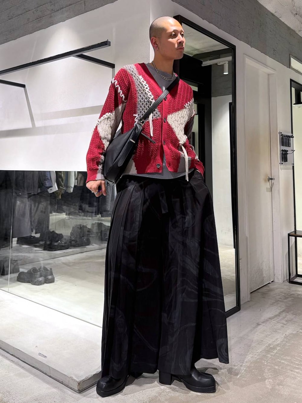 ブラック系のブルゾン、グレー系のその他パンツ、レッド系のカーディガン/ボレロを着用したメンズの冬コーディネートの5枚目の写真