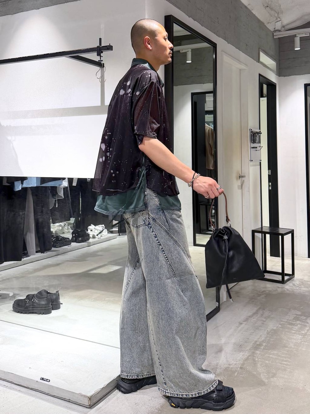 ブルー系のデニムパンツ、ブラック系のサンダル、ブラック系のショルダーバッグを着用したメンズの夏コーディネートの4枚目の写真