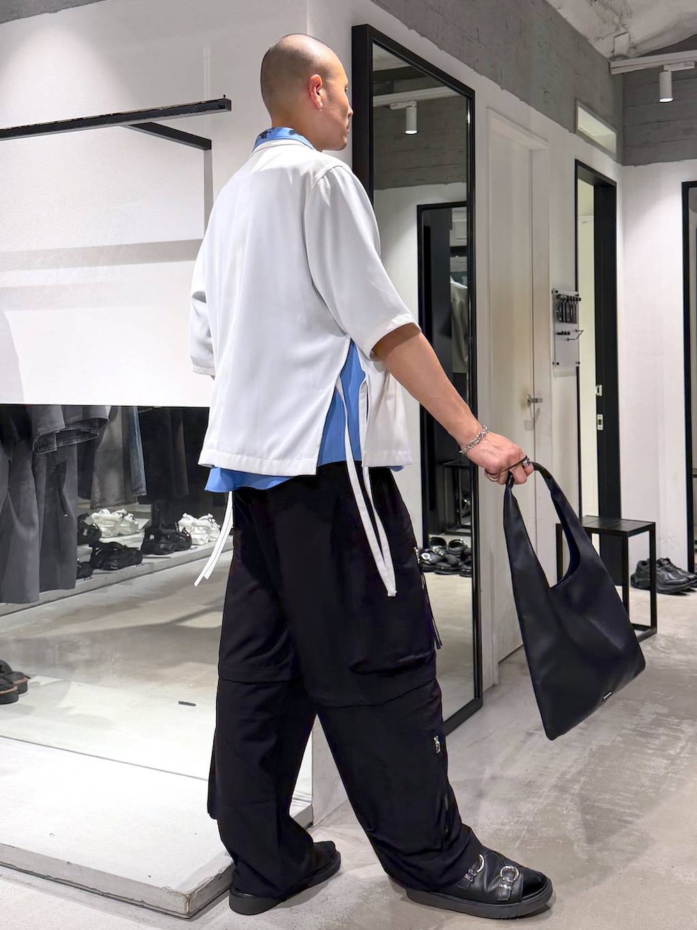 ブルー系のシャツ/ブラウス、ブラック系のトートバッグ、ブラック系のサンダルを着用したメンズの夏コーディネートの4枚目の写真