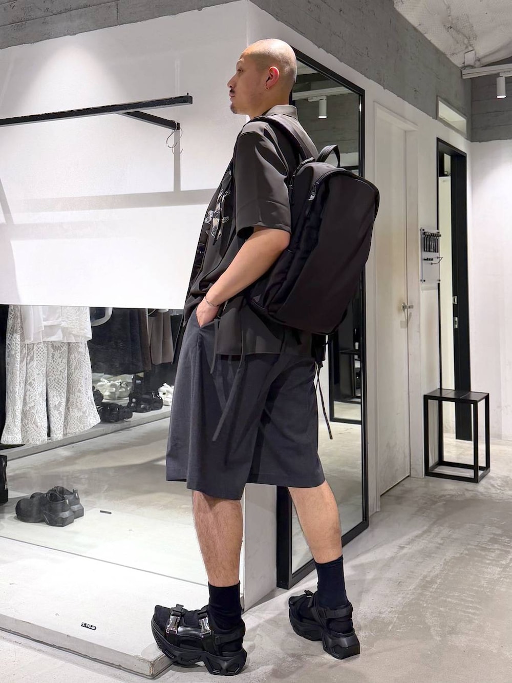 ブラック系のサンダル、ホワイト系のTシャツ/カットソー、ブラック系のバックパック/リュックを着用したメンズの夏コーディネートの2枚目の写真