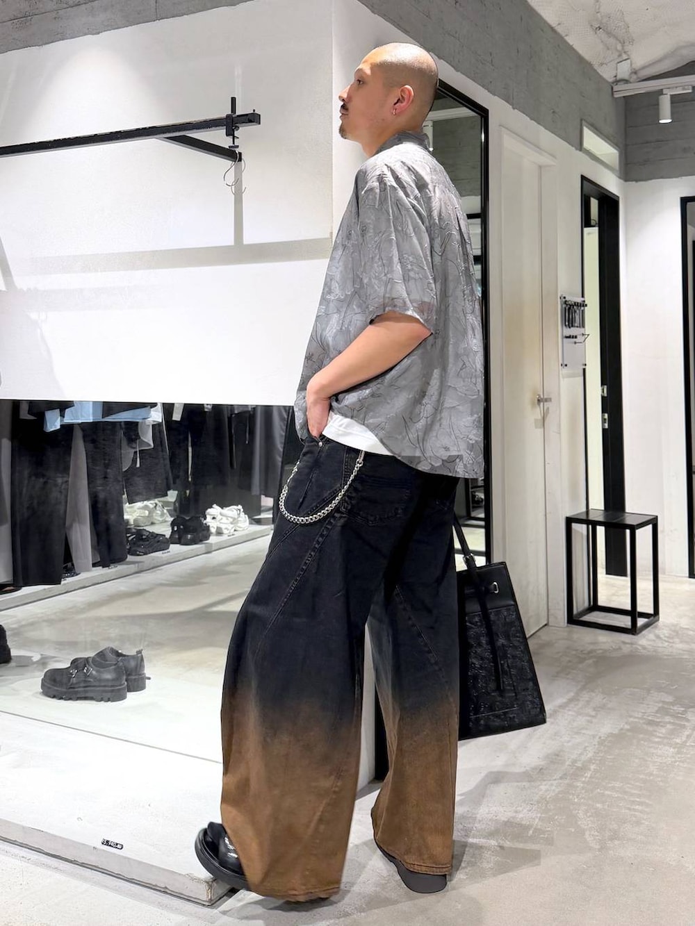 オレンジ系のデニムパンツ、ホワイト系のTシャツ/カットソー、ブラック系のサンダルを着用したメンズの夏コーディネートの2枚目の写真