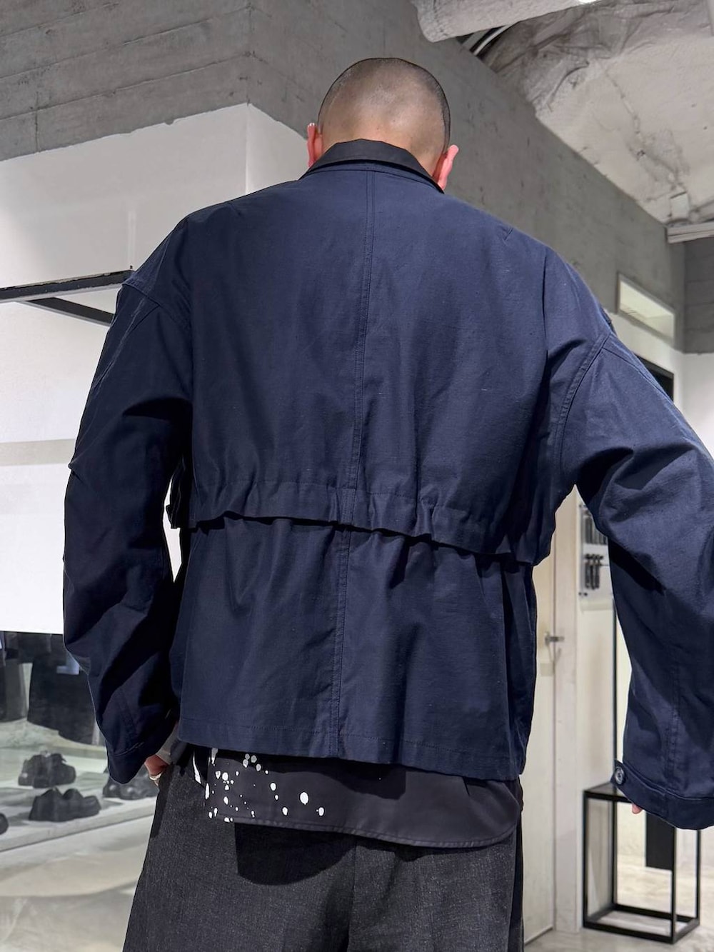 ブラック系のスニーカー、ブラック系のスラックス、ブラック系のトートバッグを着用したメンズの春コーディネートの5枚目の写真