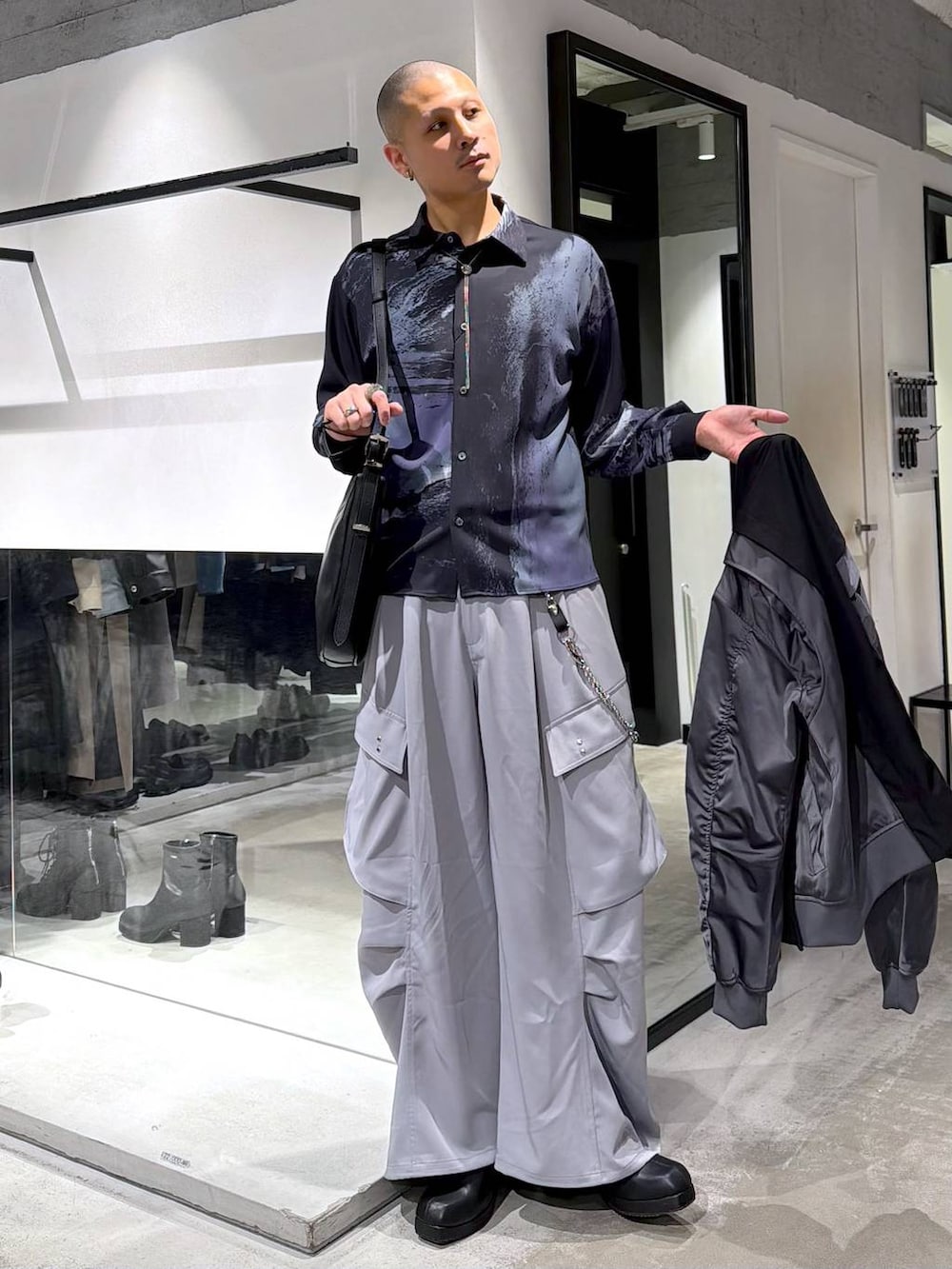 ブラック系のブーツ、ブラック系のショルダーバッグ、ブラック系のテーラードジャケットを着用したメンズの冬コーディネートの5枚目の写真