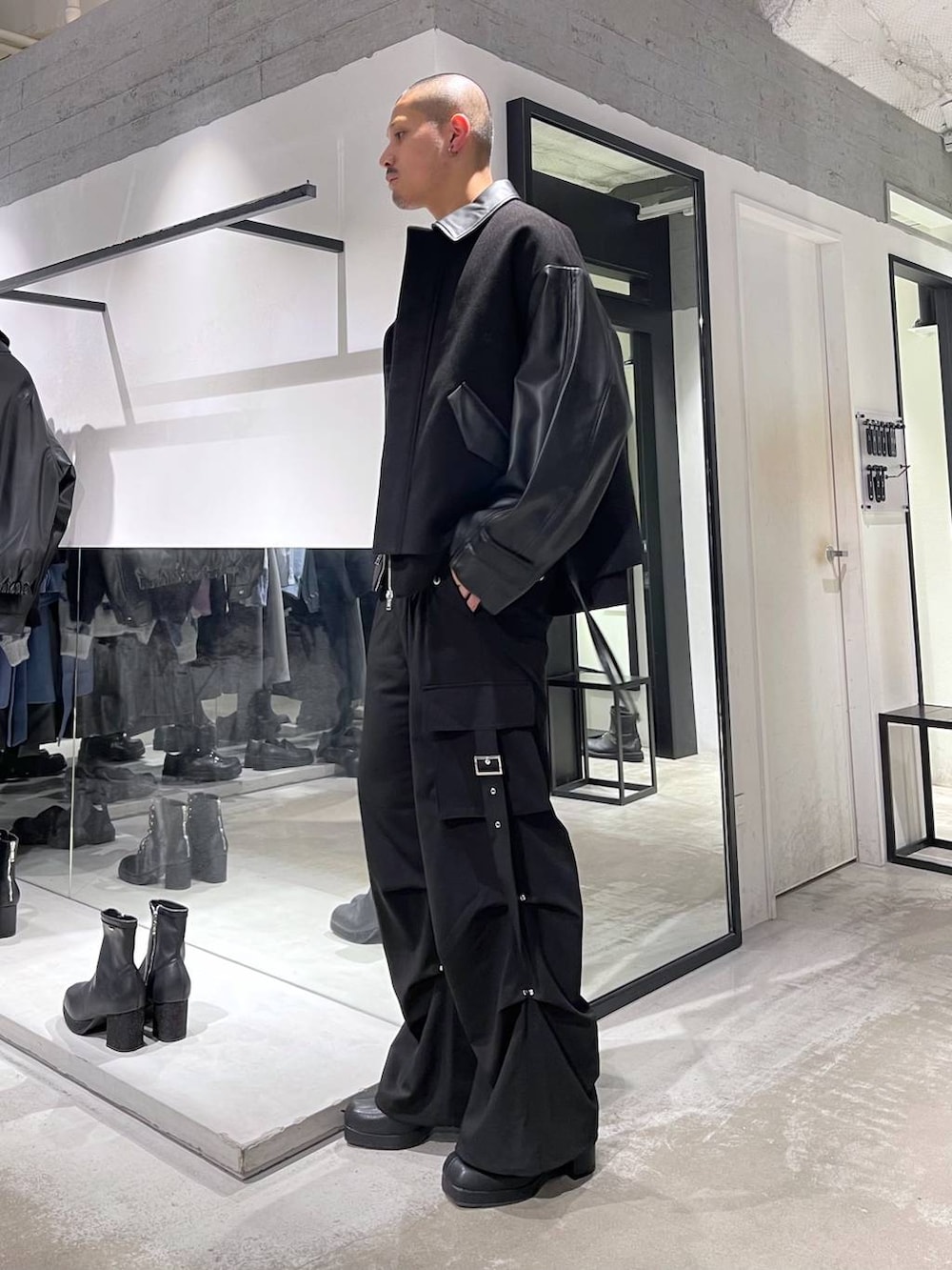 ブラック系のブルゾン、ブラック系のブーツ、ブラック系のカーゴパンツを着用したメンズの冬コーディネートの2枚目の写真