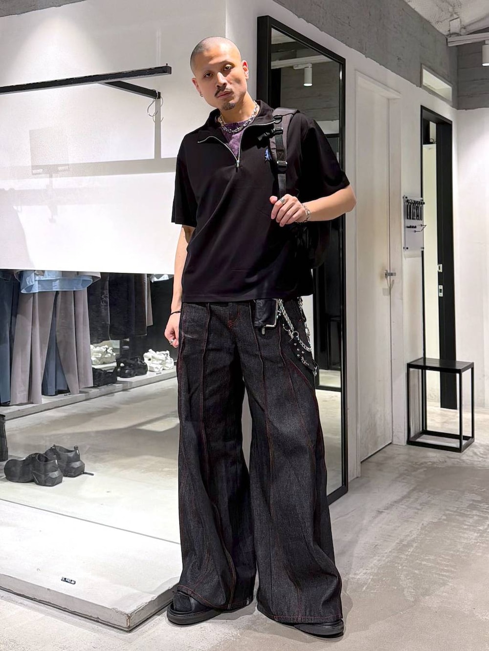 ブラック系のデニムパンツ、パープル系のTシャツ/カットソー、ブラック系のバックパック/リュックを着用したメンズの夏コーディネートの2枚目の写真