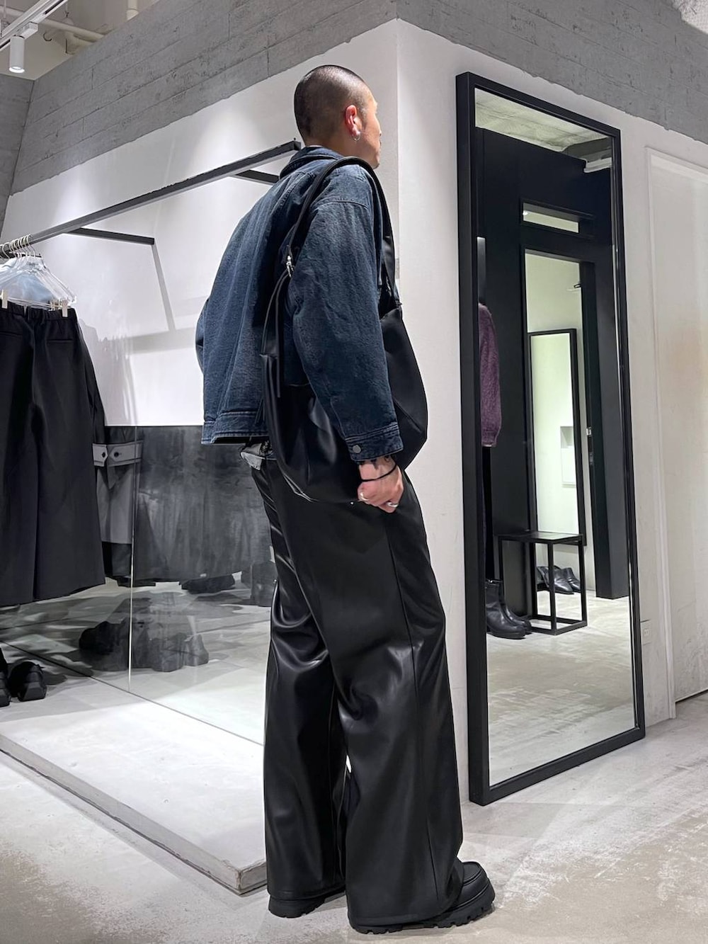 ブラック系のスラックス、ブラック系のドレスシューズ、ブラック系のショルダーバッグを着用したメンズの冬コーディネートの4枚目の写真