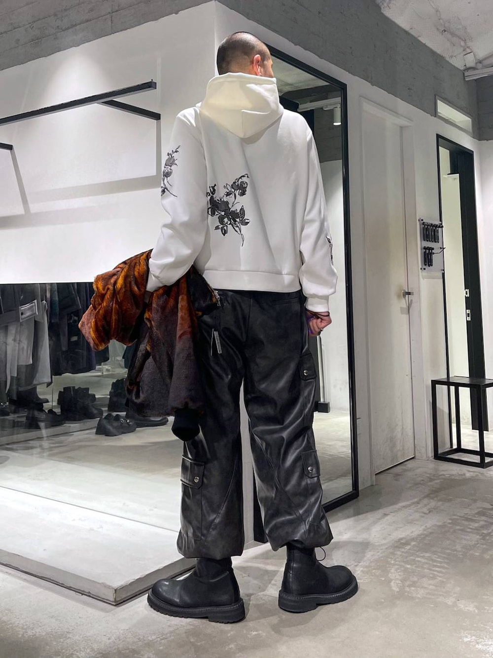 オレンジ系のブルゾン、グレー系のカーゴパンツ、ブラック系のブーツを着用したメンズの秋コーディネートの6枚目の写真