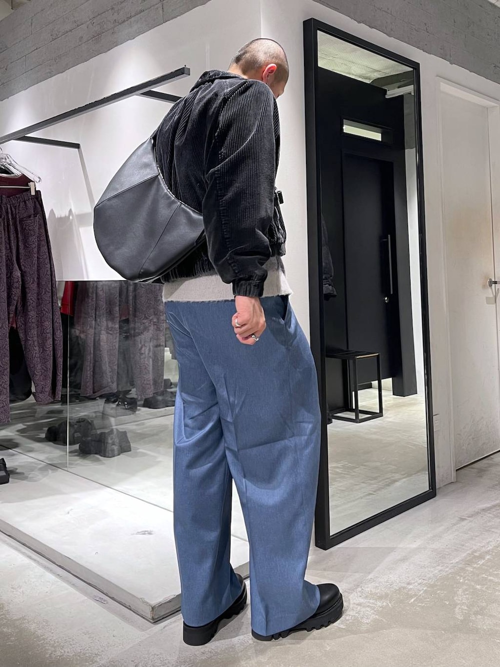 ブラック系のブルゾン、ブラック系のショルダーバッグ、ブラック系のドレスシューズを着用したメンズの冬コーディネートの4枚目の写真