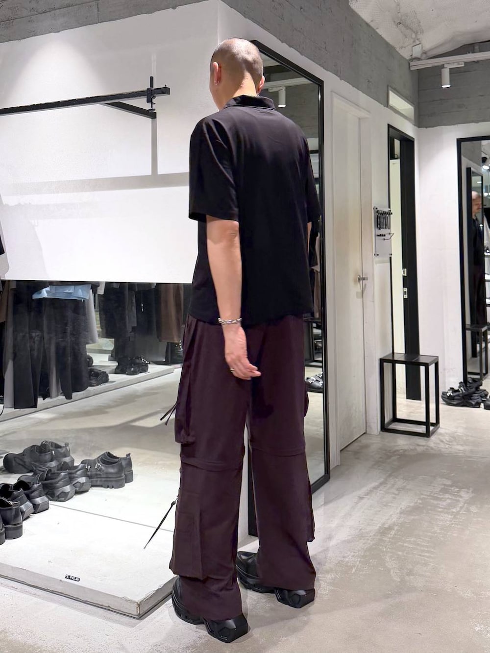 ブラック系のスニーカー、ブラウン系のカーゴパンツ、ブラック系のTシャツ/カットソーを着用したメンズの夏コーディネートの3枚目の写真